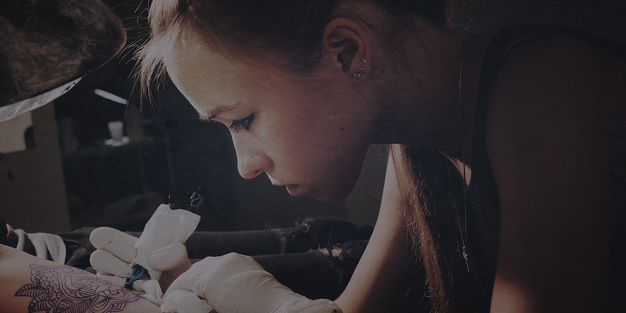 woman tattooing arm