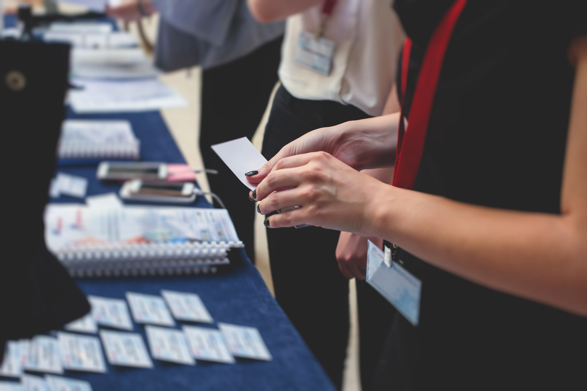 Person examining a name badge at event table.