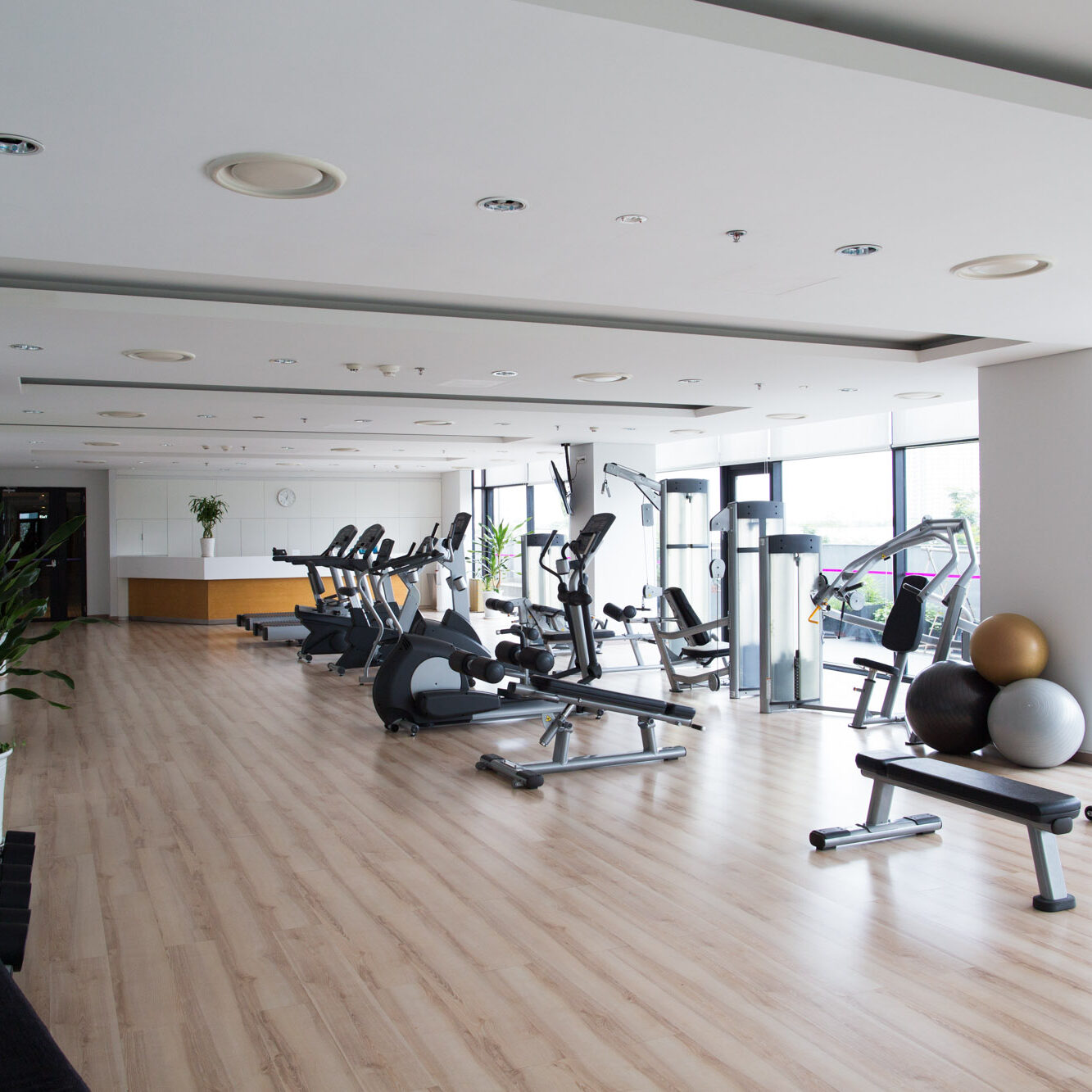 Big light fitness gym interior with sports equipment in hotel